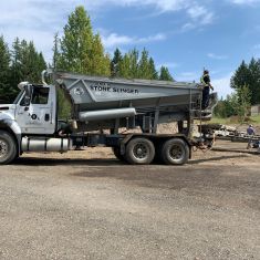 Stoneslinger placing drain rock for big o